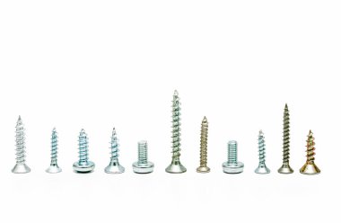 Beyaz arkaplanda farklı türde metal vidalar ve cıvatalar