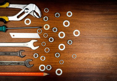 Farklı aletler - anahtarlar, tornavida, kahverengi ahşap arka planda ev onarımı için kalem bıçağı