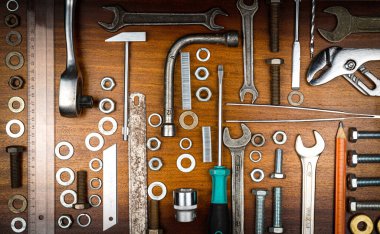 Düğümleme tarzı fotoğraf - kahverengi ahşap dokunun arka planında ev onarımı için çeşitli ögeler ve araçlar