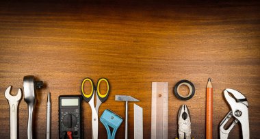 Düğümleme tarzı fotoğraf - kahverengi ahşap dokunun arka planında ev onarımı için çeşitli ögeler ve araçlar