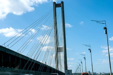 Otobandan çıkıp nehrin karşısındaki beton köprüye gidin. Mavi gökyüzü ve şehrin arka planında.
