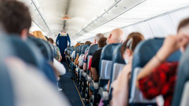 Uçak kabini - koridor koltukları ve uçuş sırasında yolcular