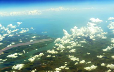 Karanın, nehrin ve denizin manzarası yolcu uçağı lombozunun yüksekliğinden
