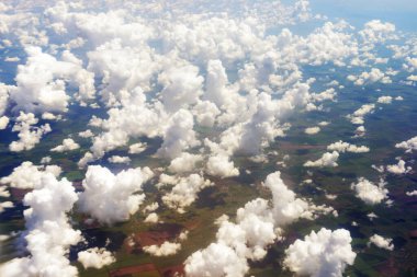 Gökyüzü görüntüsü, 12.000 metre yükseklikteki bir yolcu uçağının penceresinden beyaz bulutlarla kaplı.