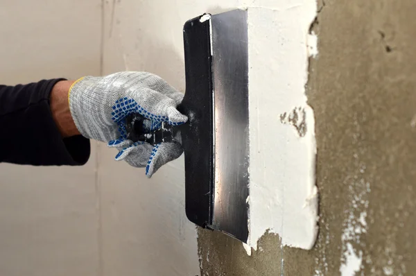 Η διαδικασία εφαρμογής ένα λευκό στόκος για τοίχο γκρι — Φωτογραφία Αρχείου