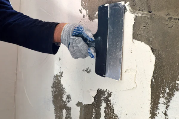 Het proces van de toepassing van een witte putty op betonnen grijze muur — Stockfoto