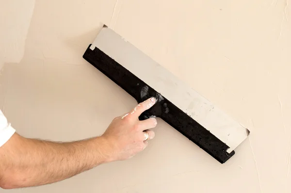 Il processo di applicazione di una spatola larga secondo strato di stucco — Foto Stock