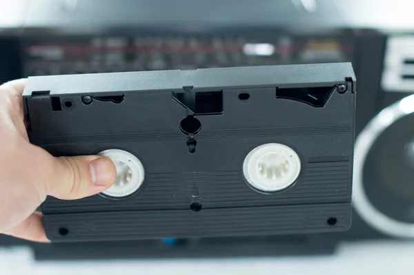 Plástico, cassete de vídeo preto nas mãos — Fotografia de Stock