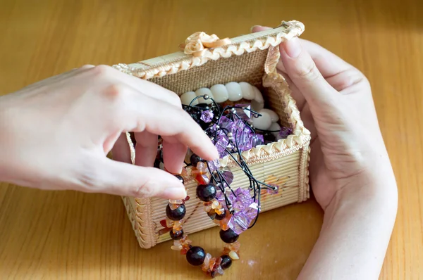 Vrouwelijke hand neemt een verschillende mooie sieraden — Stockfoto