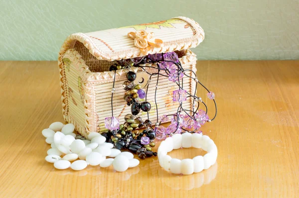 Various women's beautiful jewelry in a wicker box — Stock Photo, Image