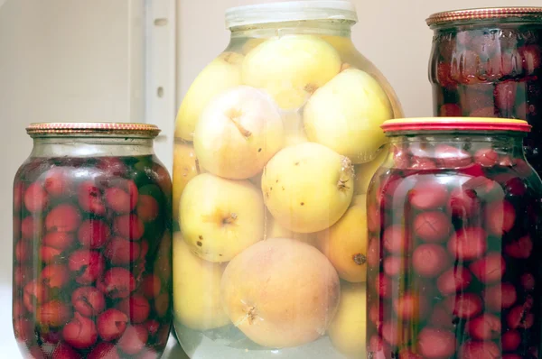 Conservation des pommes et des cerises dans un bocal en verre — Photo