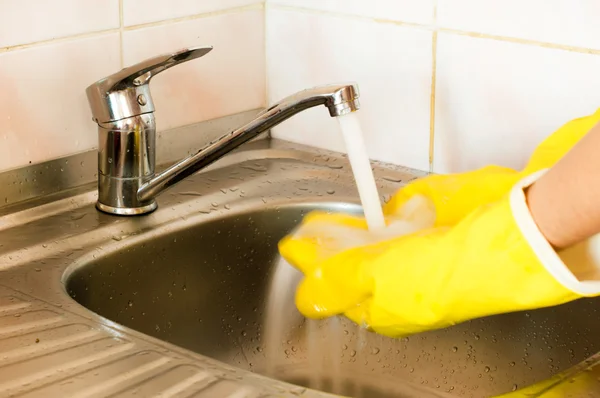 Processen med att tvätta händerna i gula handskar — Stockfoto