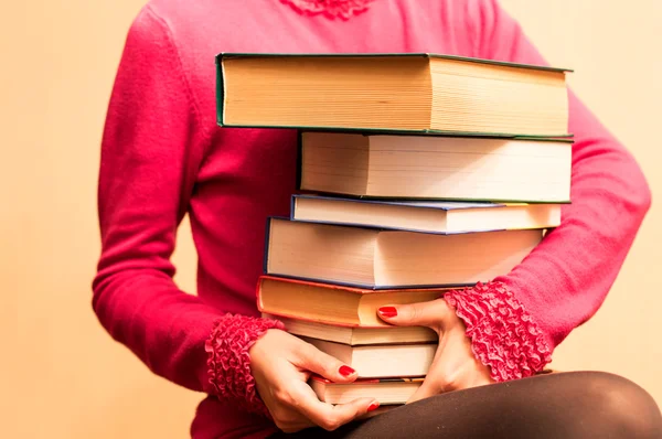 A large number of books in the hands of women — Stock Photo, Image