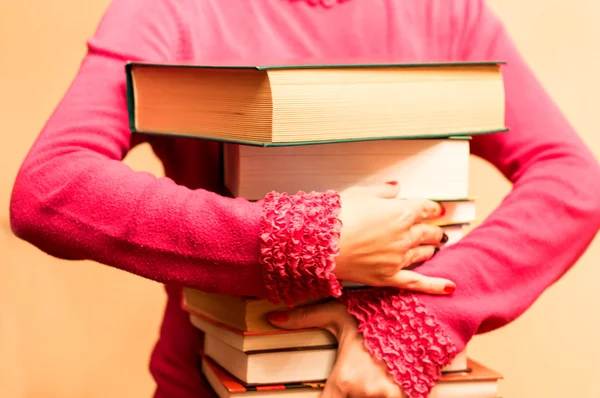 A large number of books in the hands of women — Stock Photo, Image