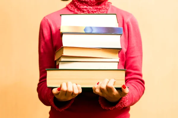 Frau im roten Pullover mit Büchern in der Hand — Stockfoto