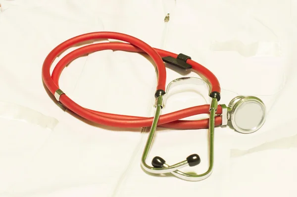 Medicinska Stetoskop för rött ljus mot en vit morgonrock — Stockfoto