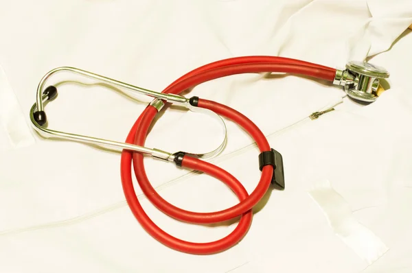 Medicinska stetoskop mot en vit morgonrock — Stockfoto
