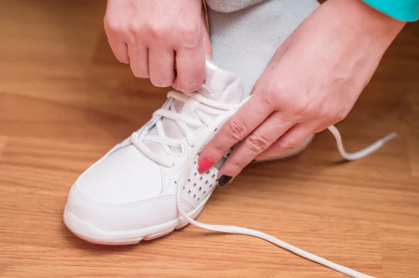 Process of clothing of white sports sneakers — Stock Photo, Image