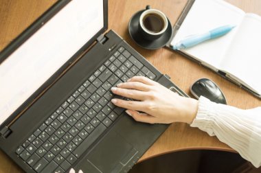 Siyah kahve ile bir dizüstü bilgisayar için çalışmak