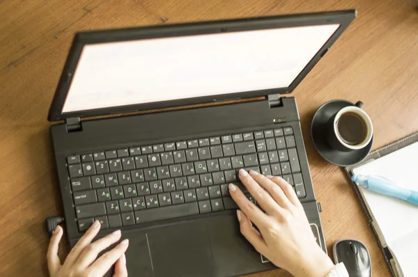 Trabalhar para um laptop com uma xícara de café preto — Fotografia de Stock