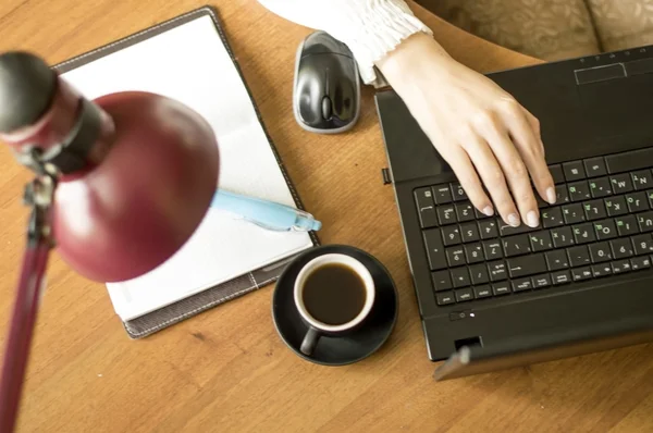 Travailler pour un ordinateur portable avec une tasse de café noir — Photo
