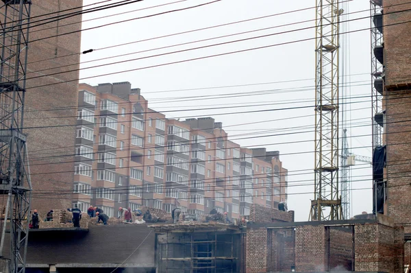 Un gran número de trabajadores en cascos en la construcción — Foto de Stock