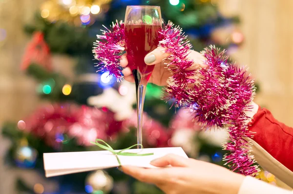 圣诞节的主题--一杯女性手中的红色起泡酒 — 图库照片