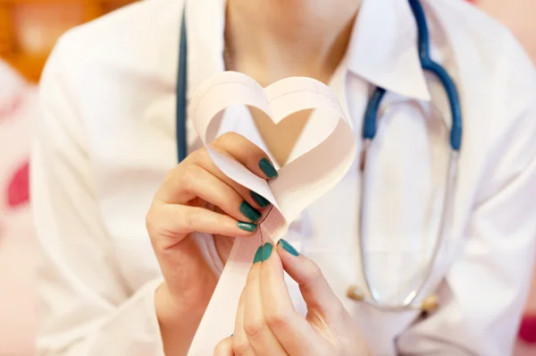 Bir doktor ile bir kalp şeklinde onun elinde cardiograms