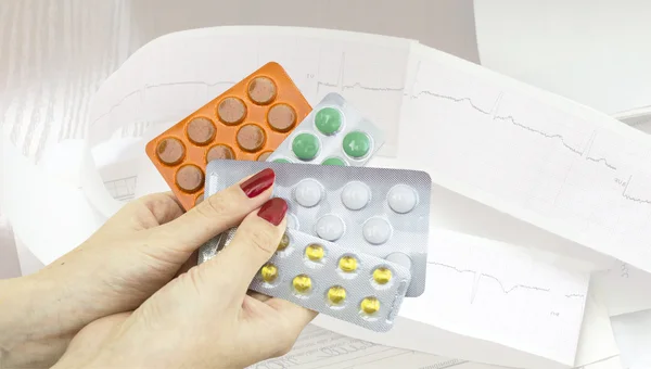 Different pharmaceutical tablets in women's hands — Stock Photo, Image