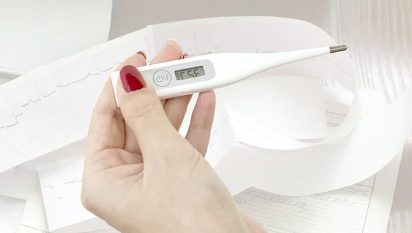 Electronic thermometer in the women's hands — Stock Photo, Image