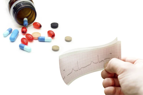 Électrocardiogramme à la main différentes pilules — Photo