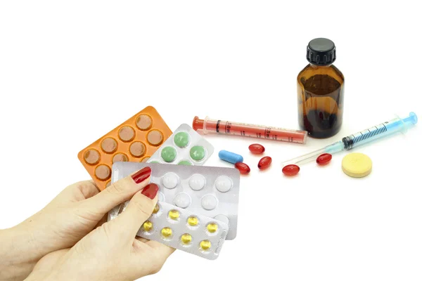 Pills in hand as well as a variety of pharmacological drugs and — Stock Photo, Image