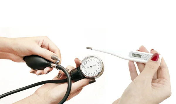 Electronic thermometer and blood pressure in women's hands — Stock Photo, Image