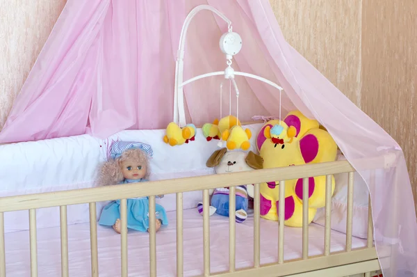 Différents peluches dans le lit bébé avec du lin orange — Photo