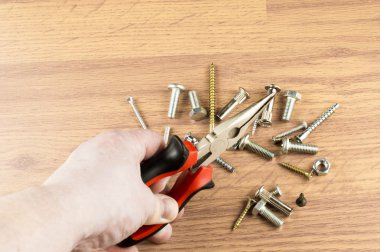 Pense çeşitli cıvata bir arka plan üzerinde elinde 