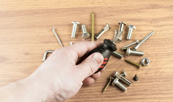 Schraubenzieher in der Hand des Meisters auf dem Hintergrund von Vario — Stockfoto