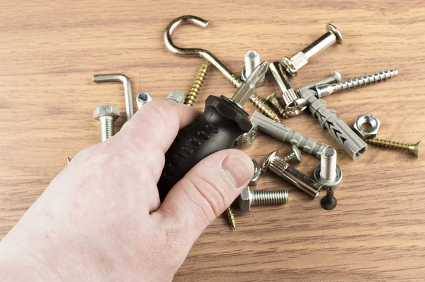 Screwdriver in the hand of the master on the background of vario — Stock Image Screwdriver in the hand of the master on the background of vario Stock Picture