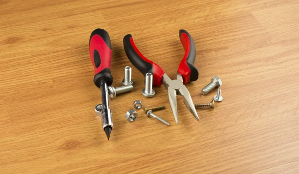 Screwdriver, pliers and various bolts — Stock Photo, Image