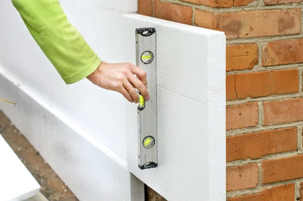 Ebenheit der Wand mit einer Ebene prüfen Stockfoto