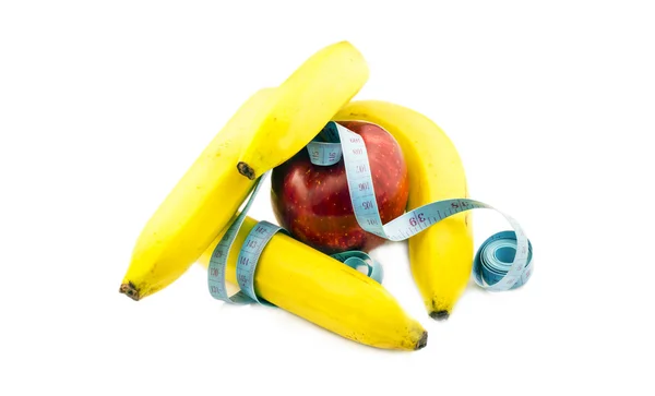 Banana and apple wrapped in measuring tape — Stock Photo, Image