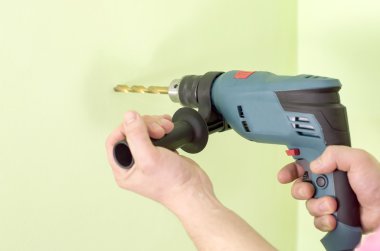 Elektrikli matkaplar elinde tutan 