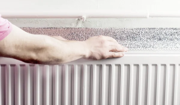 Touching hands to section aluminum radiator — Stock Photo, Image