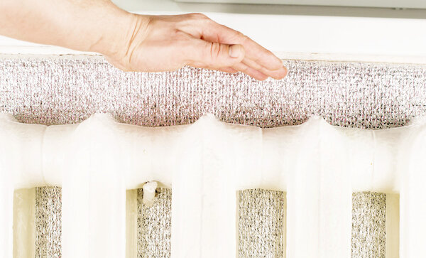 Подогрев рук возле железного радиатора
