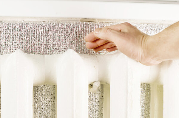 Подогрев рук возле железного радиатора
