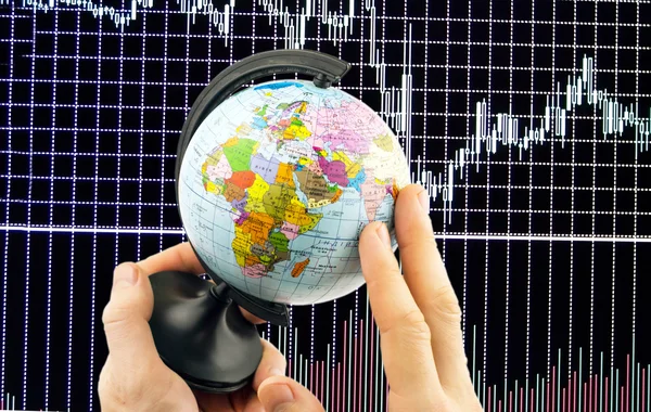 Globo en las manos en un fondo de diagramas Finanzas — Foto de Stock