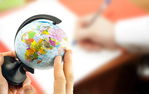 Globe in the hands on the background blurred office background — Stock Photo, Image