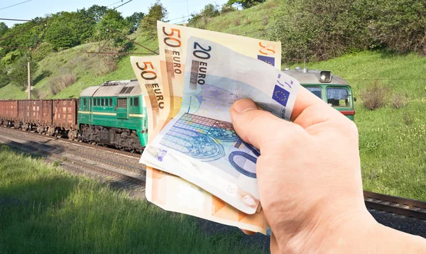 The euro in his hand on a background of train — Stock Photo, Image