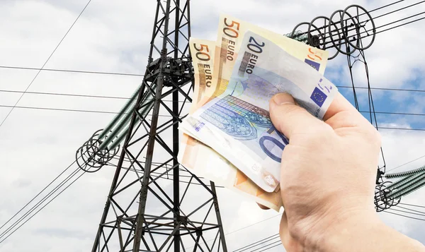 The euro in hand on the background of power lines — Stock Photo, Image