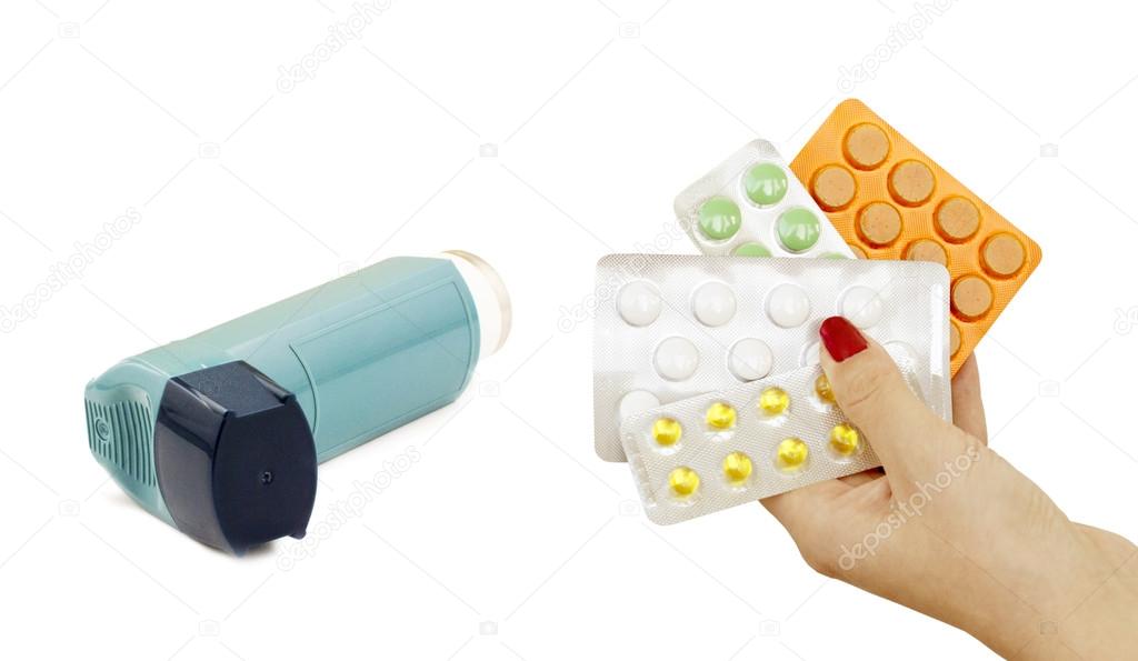 Inhaler to treat asthma and pills in hand 