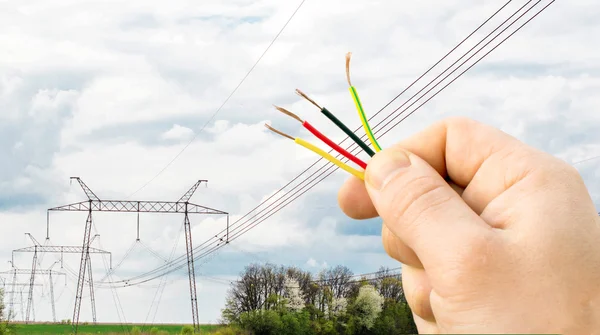 Wires in hand on the background Power lines — Stock Photo, Image